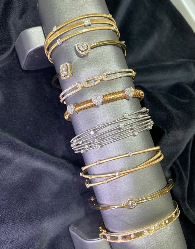 Gold and white gold diamond bangles on a display tower